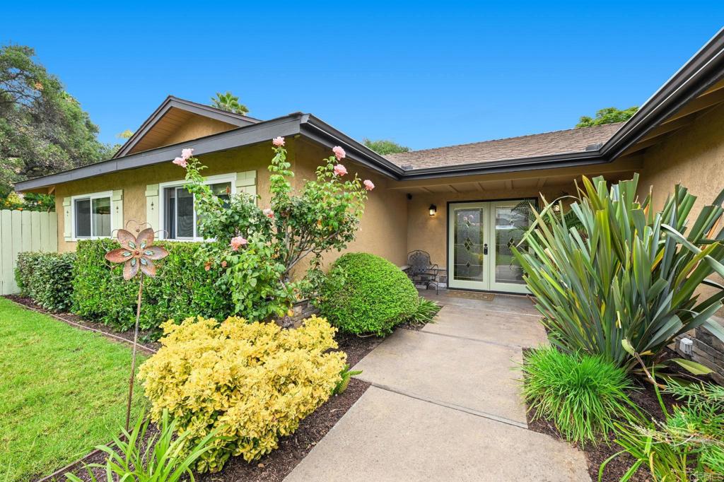 a view of a house with a small yard and flower plants