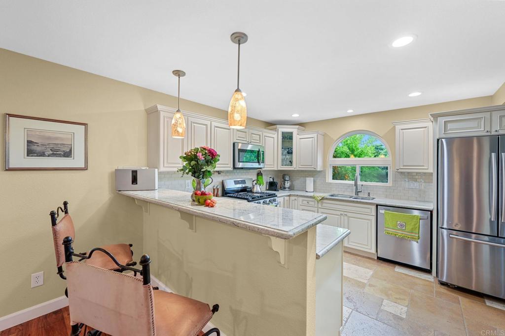 3625 Laketree Drive Fallbrook, CA 92028 - Photo 3 of 52 a kitchen with stainless steel appliances a sink a refrigerator a center island and a cabinets