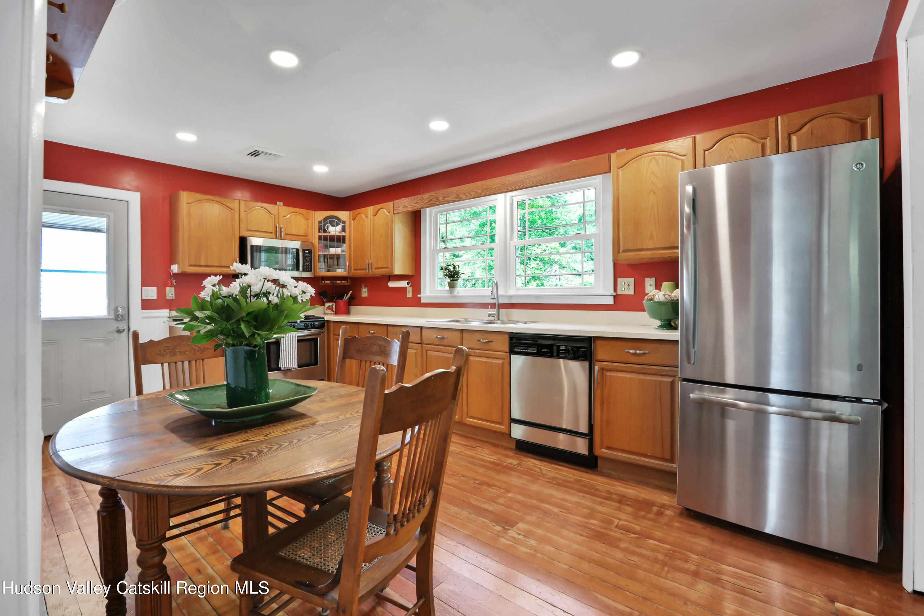 667 Albany Post Road New Paltz, NY 12561 - Photo 17 of 44 a kitchen with stainless steel appliances granite countertop a refrigerator a sink dishwasher and a dining table with wooden floor