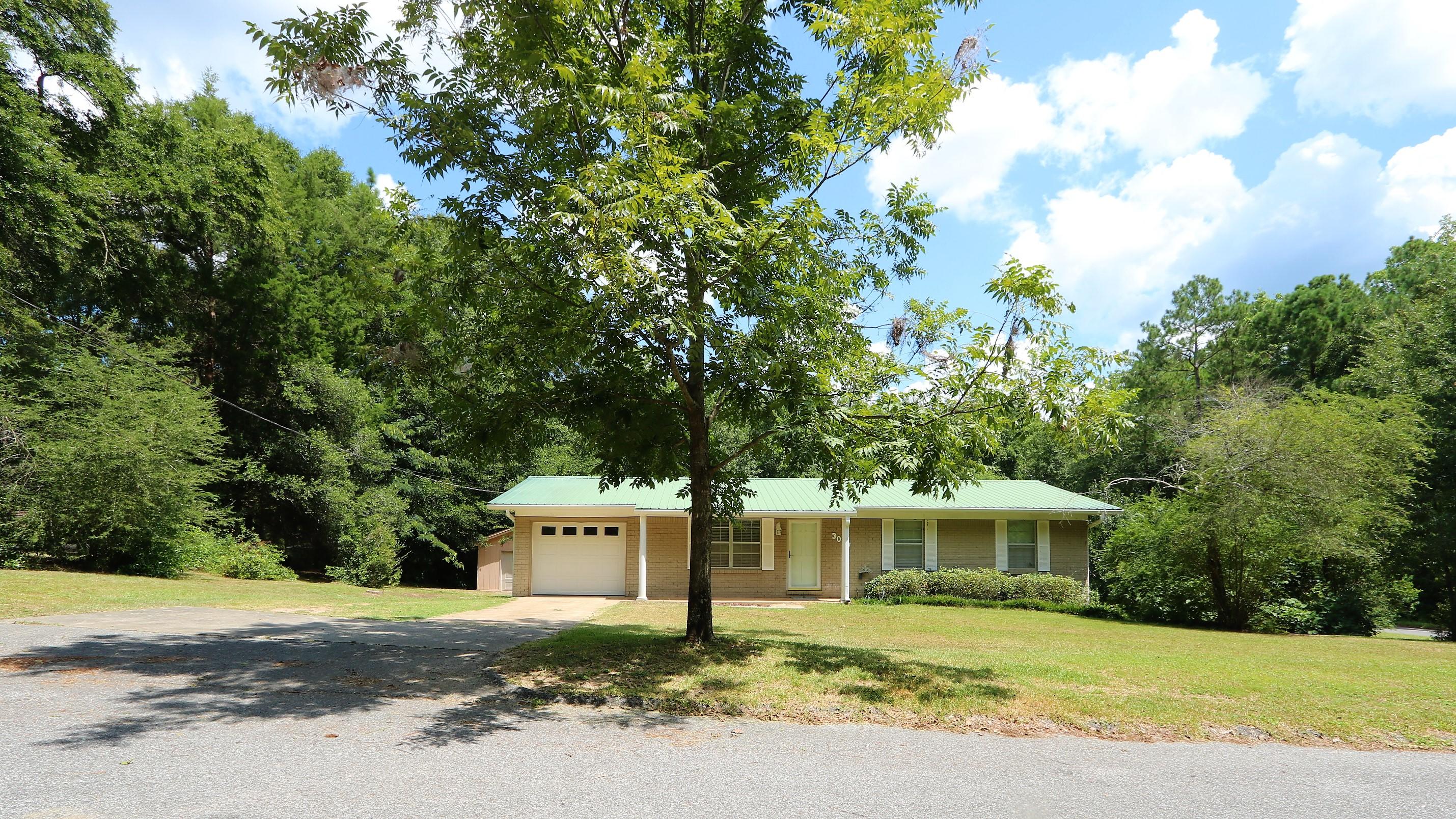 3097 Bay Ridge Drive Crestview, FL 32539 - Photo 1 of 21 a front view of a house with a garden and trees