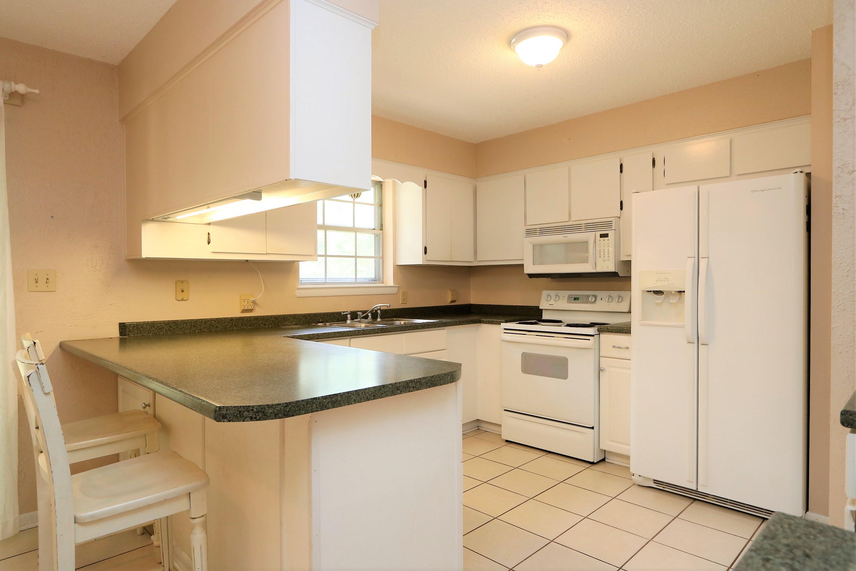 3097 Bay Ridge Drive Crestview, FL 32539 - Photo 8 of 21 a kitchen with stainless steel appliances granite countertop a refrigerator sink and white cabinets