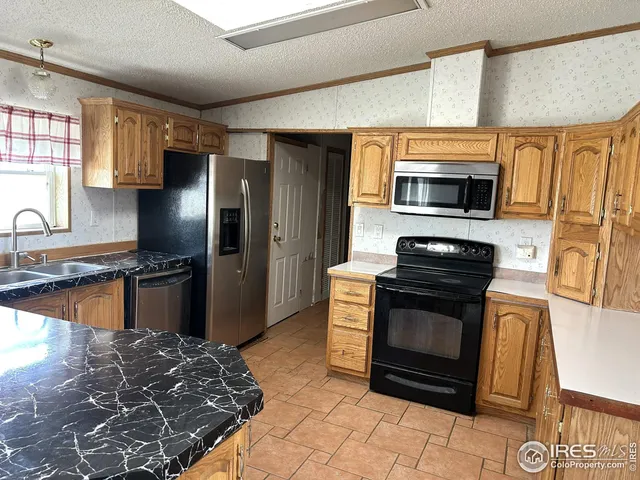 a kitchen with stainless steel appliances granite countertop a stove microwave and refrigerator