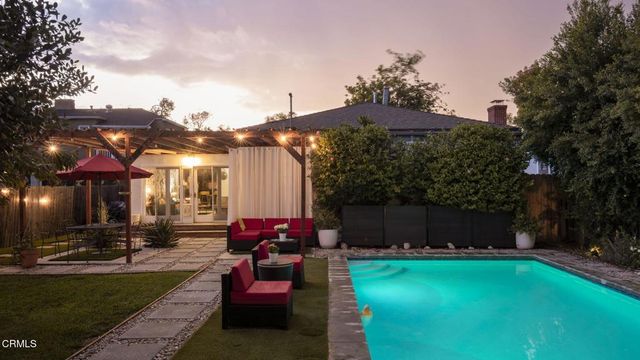 a view of a house with backyard and sitting area