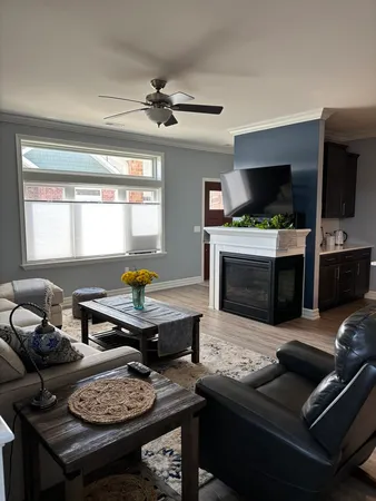 a living room with furniture wooden floor and a large window