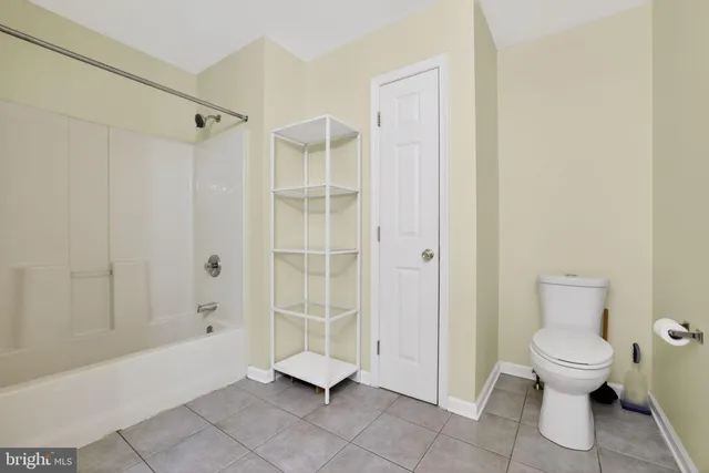 a spacious bathroom with a toilet and a shower