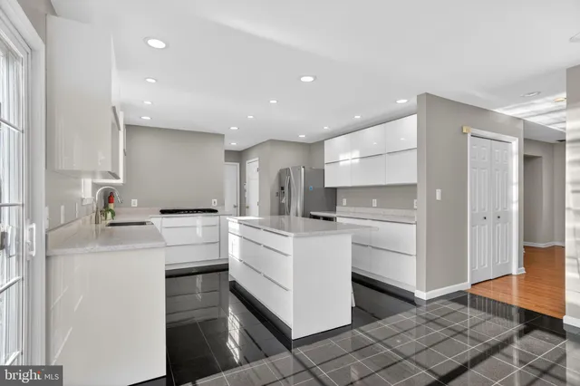 a kitchen with white cabinets and sink
