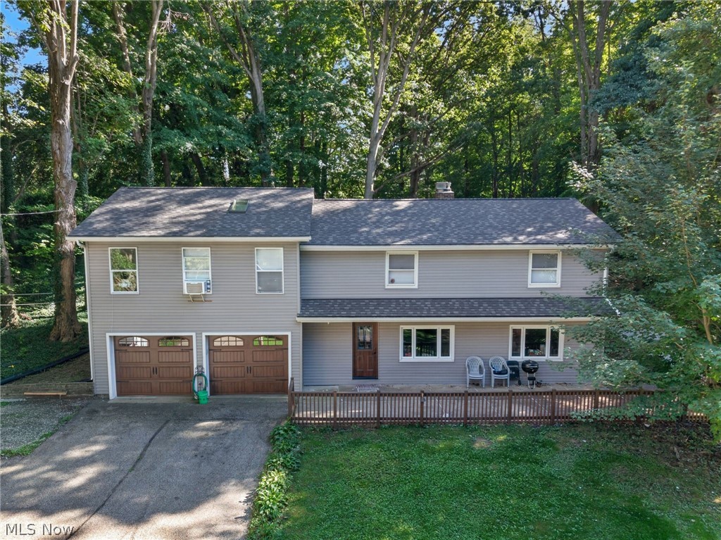 598 Randolph Road Mogadore, OH 44260 - Photo 40 of 46 Two-story residence with gray siding, a dark asphalt shingle roof, an elevated wooden deck, and a two-car attached garage