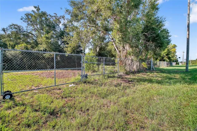 a view of backyard with wooden fence