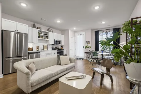 a living room with furniture kitchen view and a refrigerator