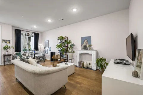 a living room with fireplace furniture and a potted plant