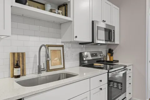 a kitchen with stainless steel appliances granite countertop a sink and a stove
