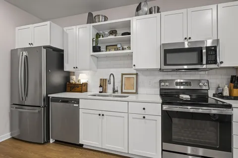 a kitchen with cabinets stainless steel appliances and wooden cabinets