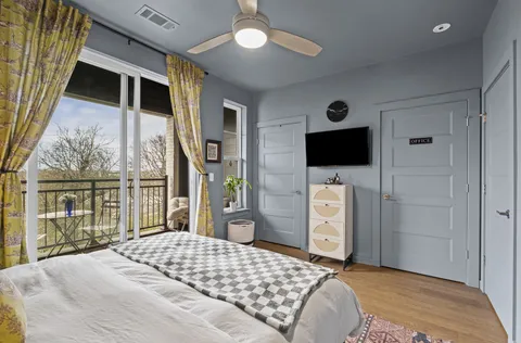 a bedroom with a bed tv and a window