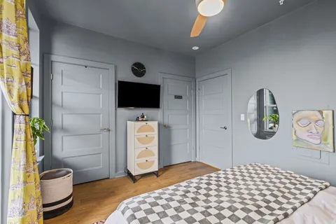 a bedroom with a bed and a flat tv screen on dresser