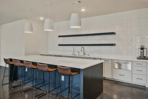 a kitchen with a sink a table and chairs
