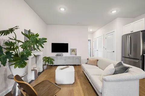 a living room with furniture a flat screen tv and a potted plant