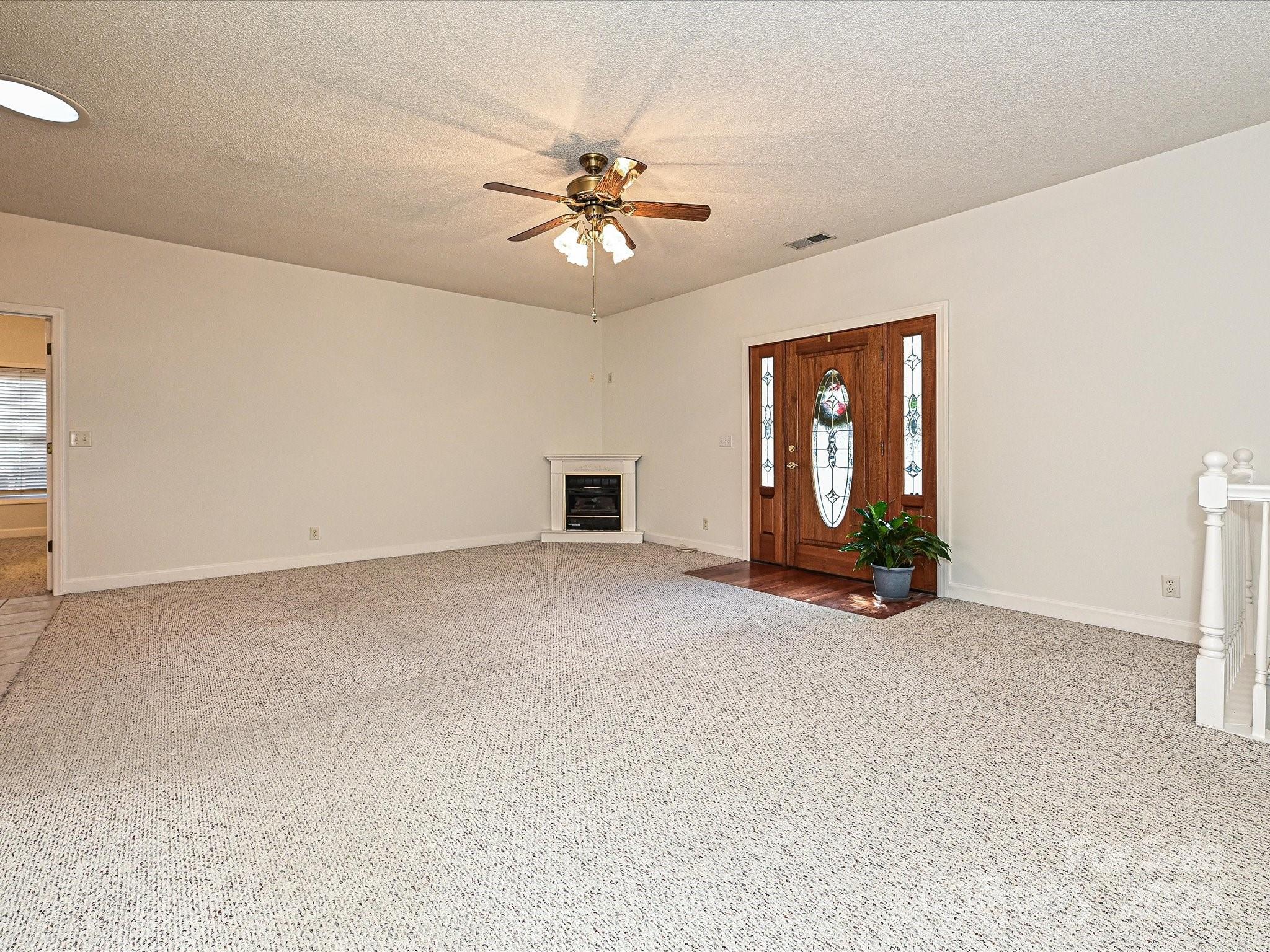25040 Timberlake Drive Tega Cay, SC 29708 - Photo 7 of 40 an empty room with chandelier fan and windows