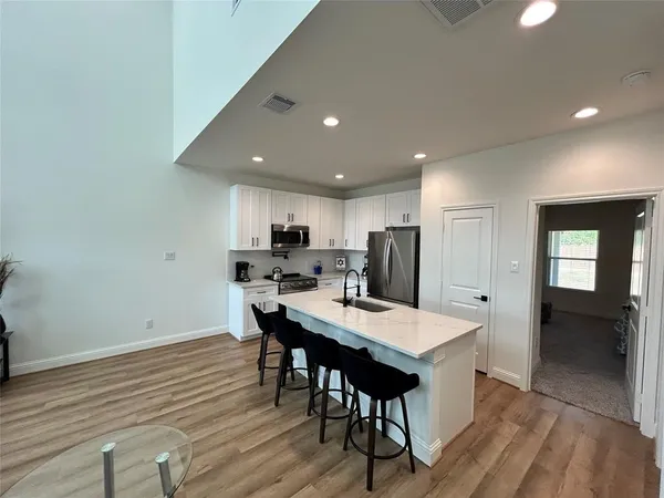 a kitchen with a dining table chairs and refrigerator