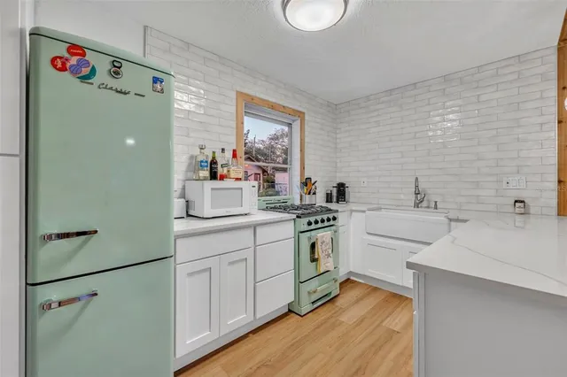 a kitchen with white cabinets and white appliances