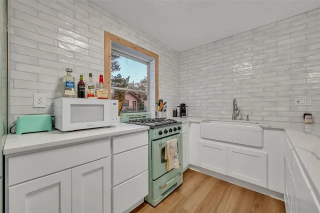 a kitchen with a stove and white cabinets