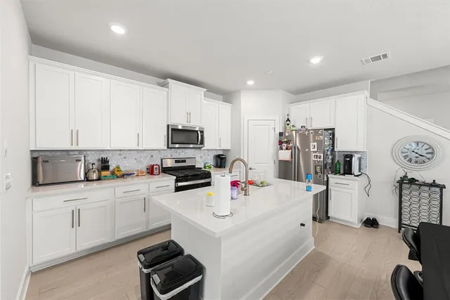 a kitchen with a sink a stove a refrigerator and cabinets