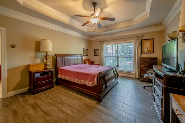 a bedroom with a bed and a flat tv screen on dresser