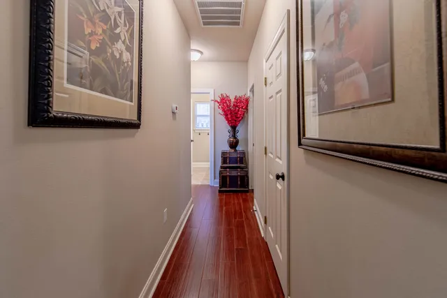 a view of a hallway with wooden floor and closet