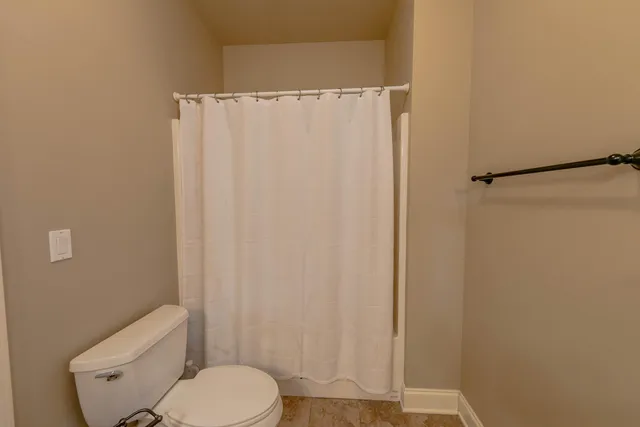 a white toilet sitting next to a shower
