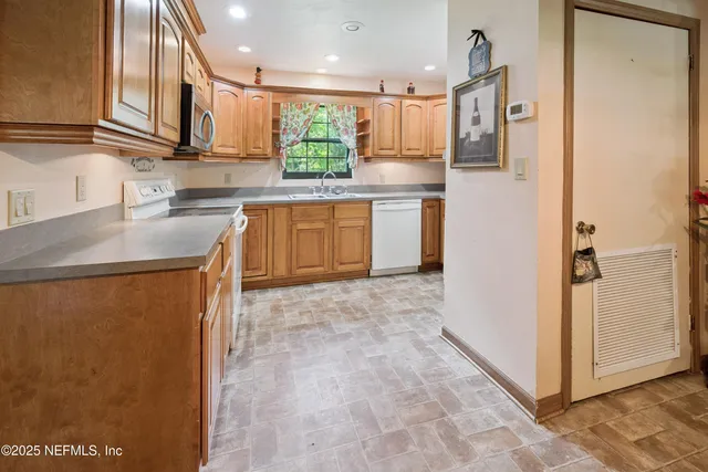 a kitchen with stainless steel appliances granite countertop a refrigerator a sink and a stove