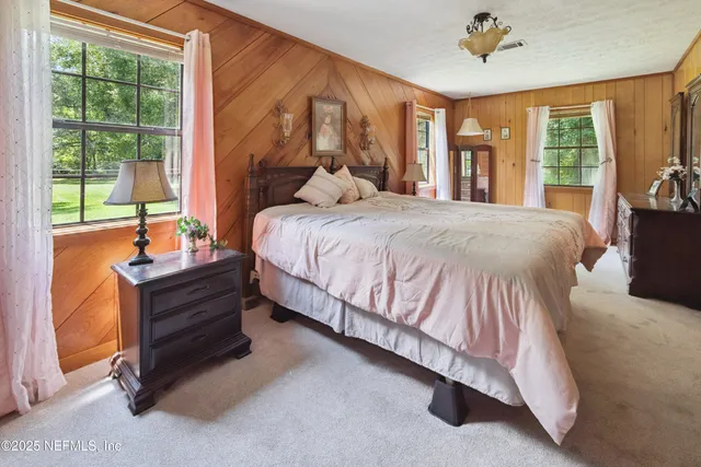 a bed sitting in a bedroom next to a window