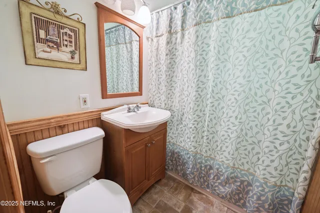a bathroom with a toilet sink and mirror