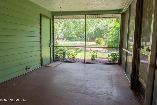 a view of empty room with sliding door and tree