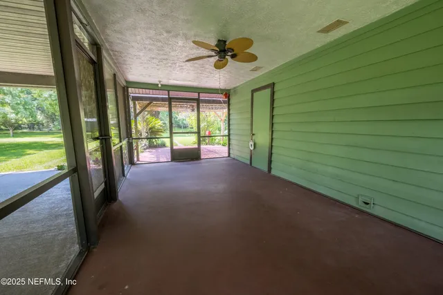 a view of a porch with a floor to ceiling window and a ceiling fan