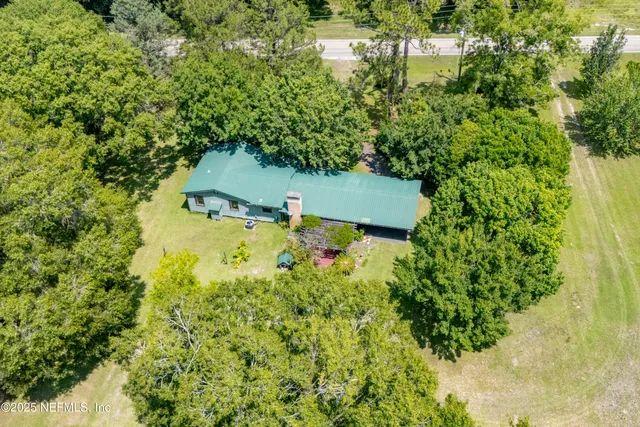 an aerial view of a house with swimming pool and garden