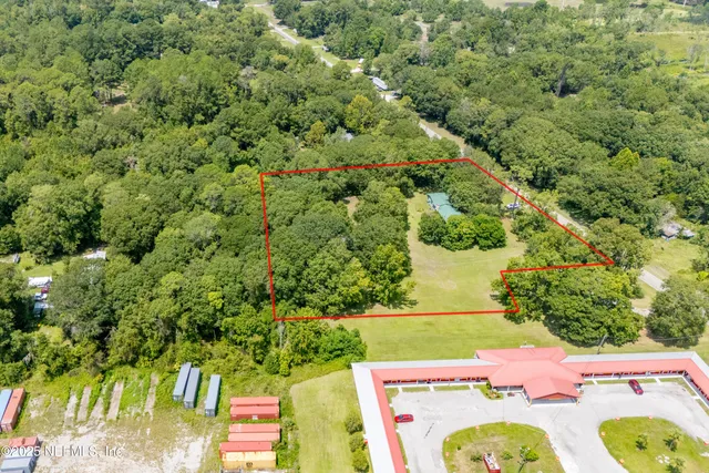 an aerial view of a residential houses with yard