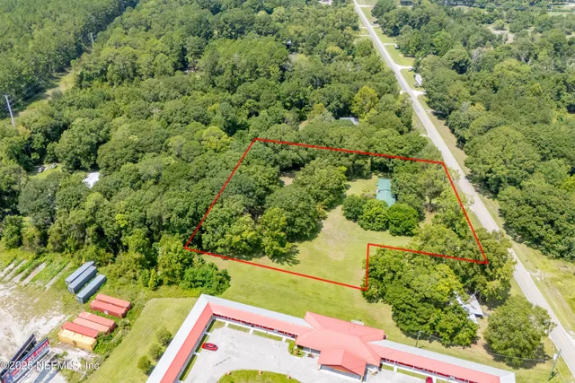 an aerial view of residential house with outdoor space and trees all around