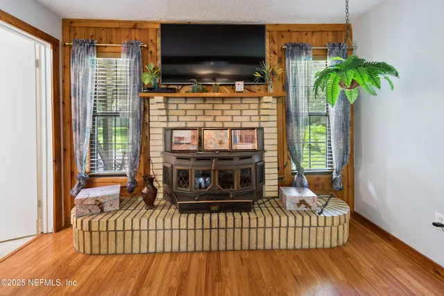 a living room with furniture floor to ceiling window and potted plants