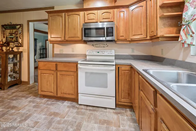 a kitchen with granite countertop a sink and a stove top oven