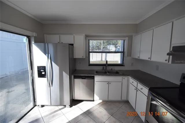 a kitchen with granite countertop a sink stove and refrigerator