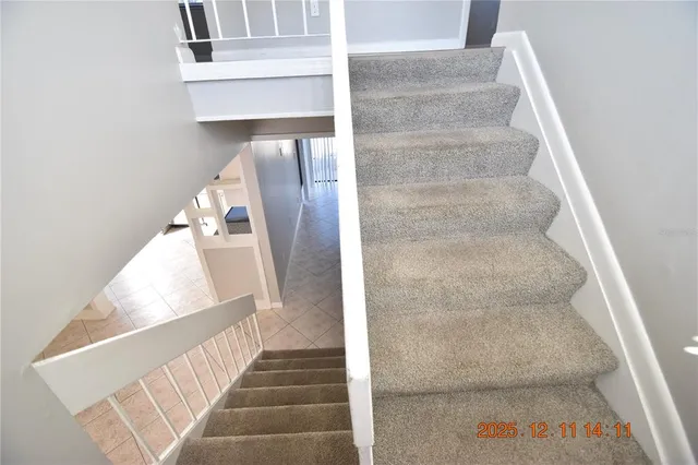 a view of staircase with white walls and door