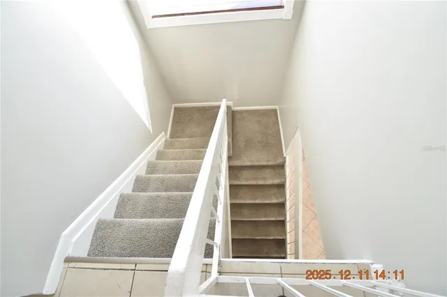 a view of staircase with white walls and white door