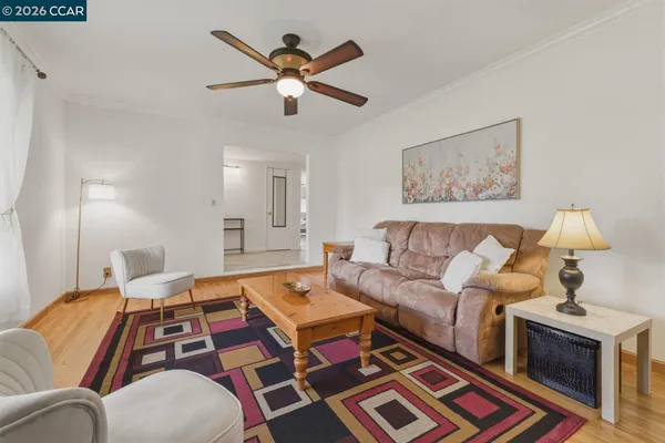 a living room with furniture and a wooden floor