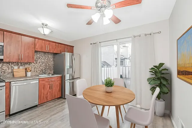 a kitchen with stainless steel appliances a dining table chairs and chandelier