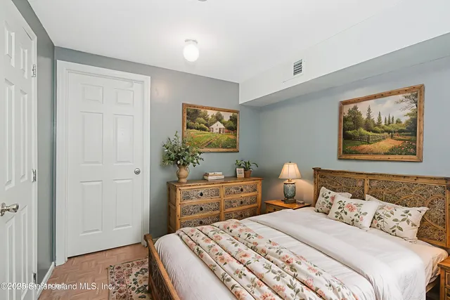 a bedroom with a bed and a painting on the wall