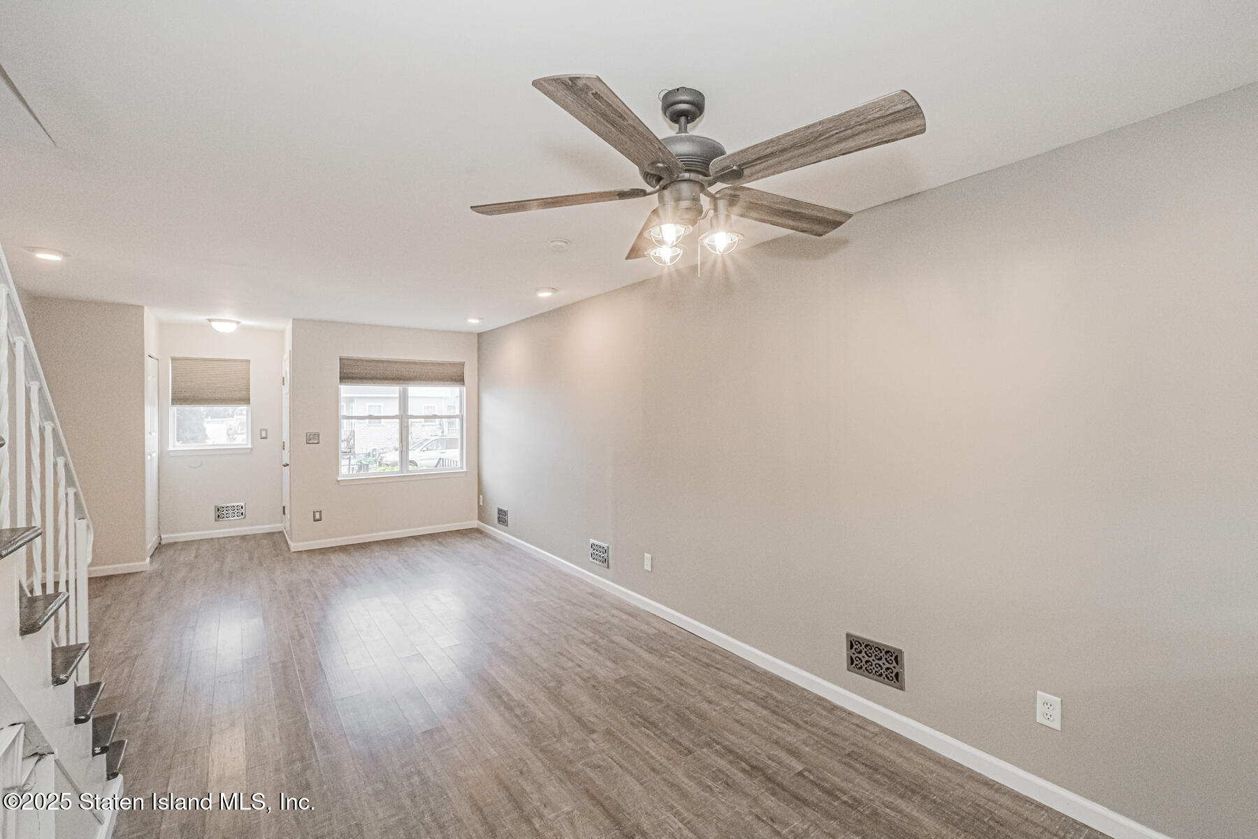 34 Lorraine Loop Staten Island, NY 10309 - Photo 6 of 33 an empty room with wooden floor fan and windows