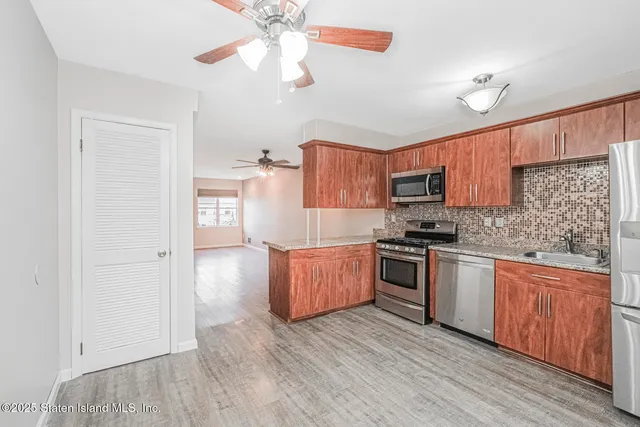 a kitchen with granite countertop wooden floors and stainless steel appliances