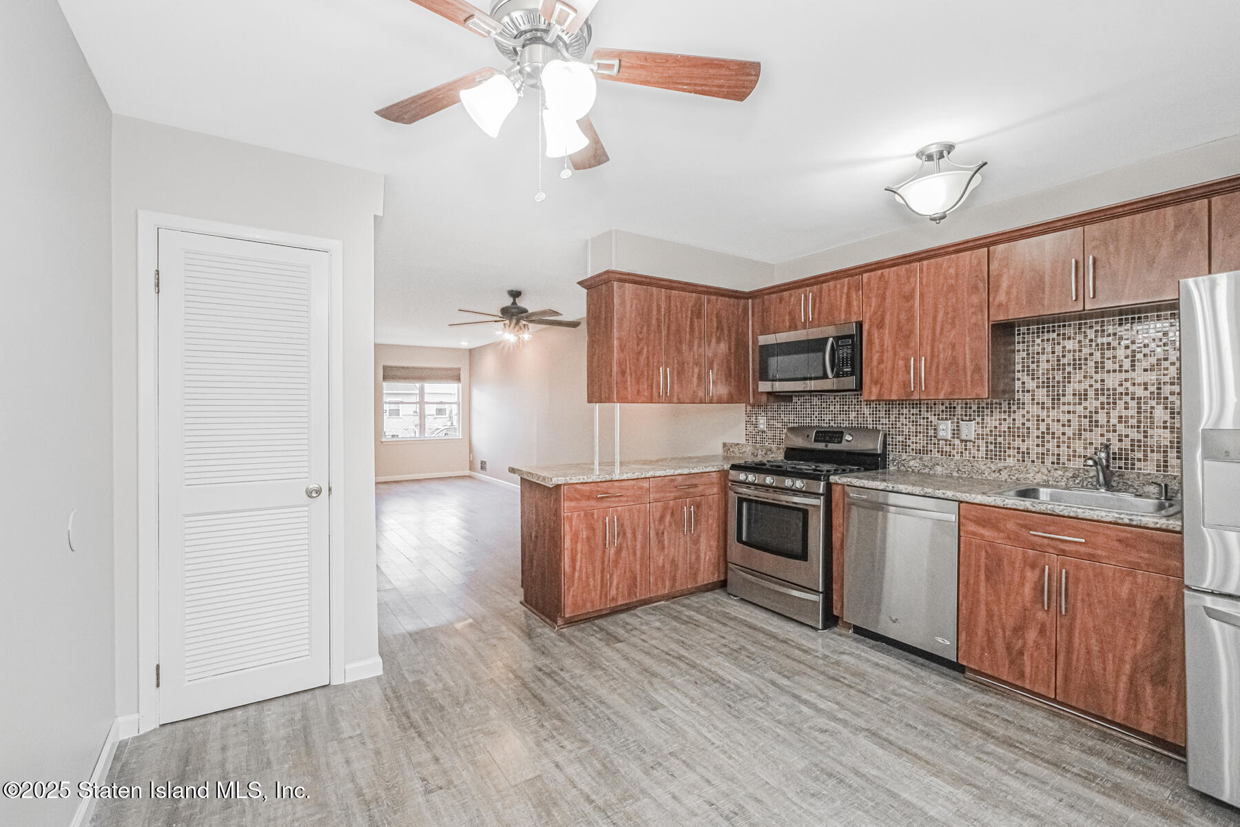 34 Lorraine Loop Staten Island, NY 10309 - Photo 8 of 33 a kitchen with granite countertop wooden floors and stainless steel appliances