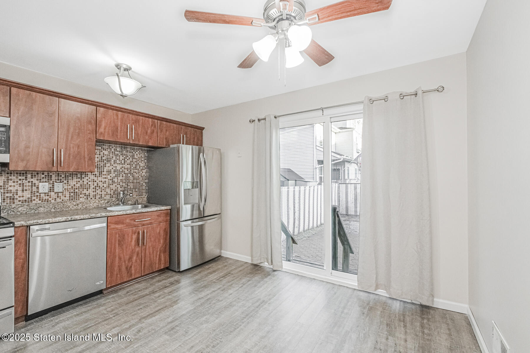 34 Lorraine Loop Staten Island, NY 10309 - Photo 10 of 33 a kitchen with stainless steel appliances granite countertop a refrigerator a sink dishwasher a stove and white cabinets with wooden floor