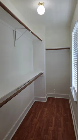 a view of a room with wooden floor and small window