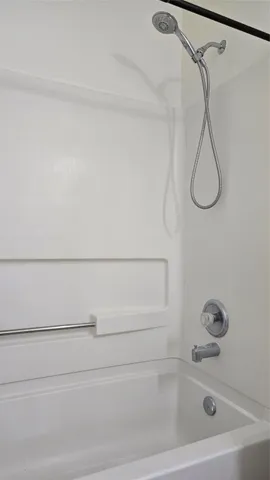 a bathroom with a bath tub with a shower